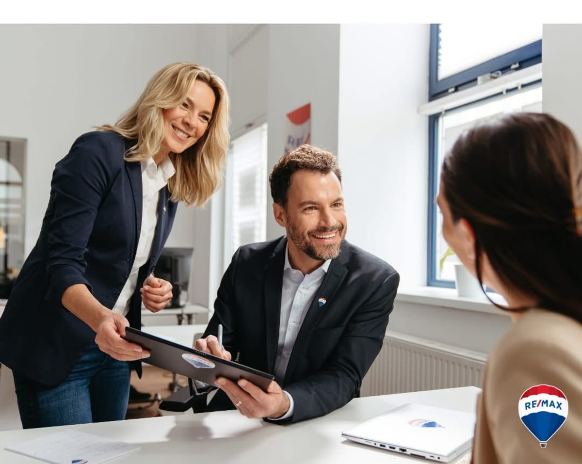 Agent RE/MAX Partnera prolazi kroz dokumentaciju s vlasnicima nekretnine